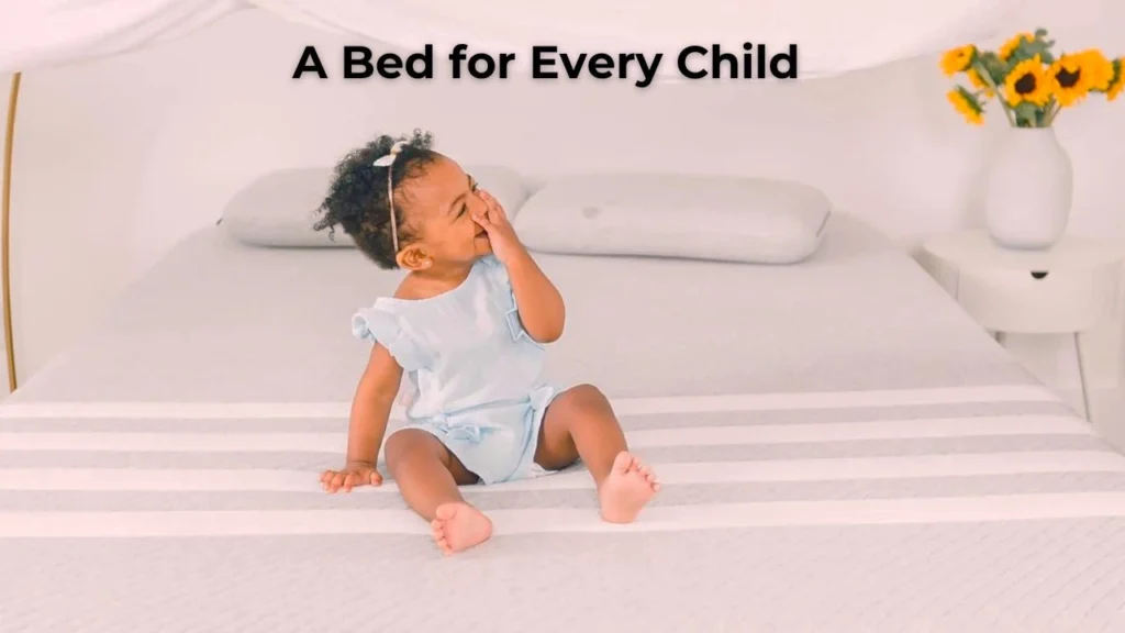 A happy child sitting on a bed with Leesa's Mattress - a socially responsible business.